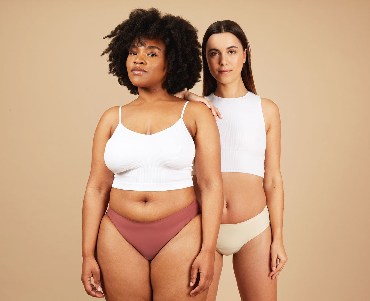 Two women wearing seamless period underwear and white vests, showcasing leakproof confidence and period comfort.