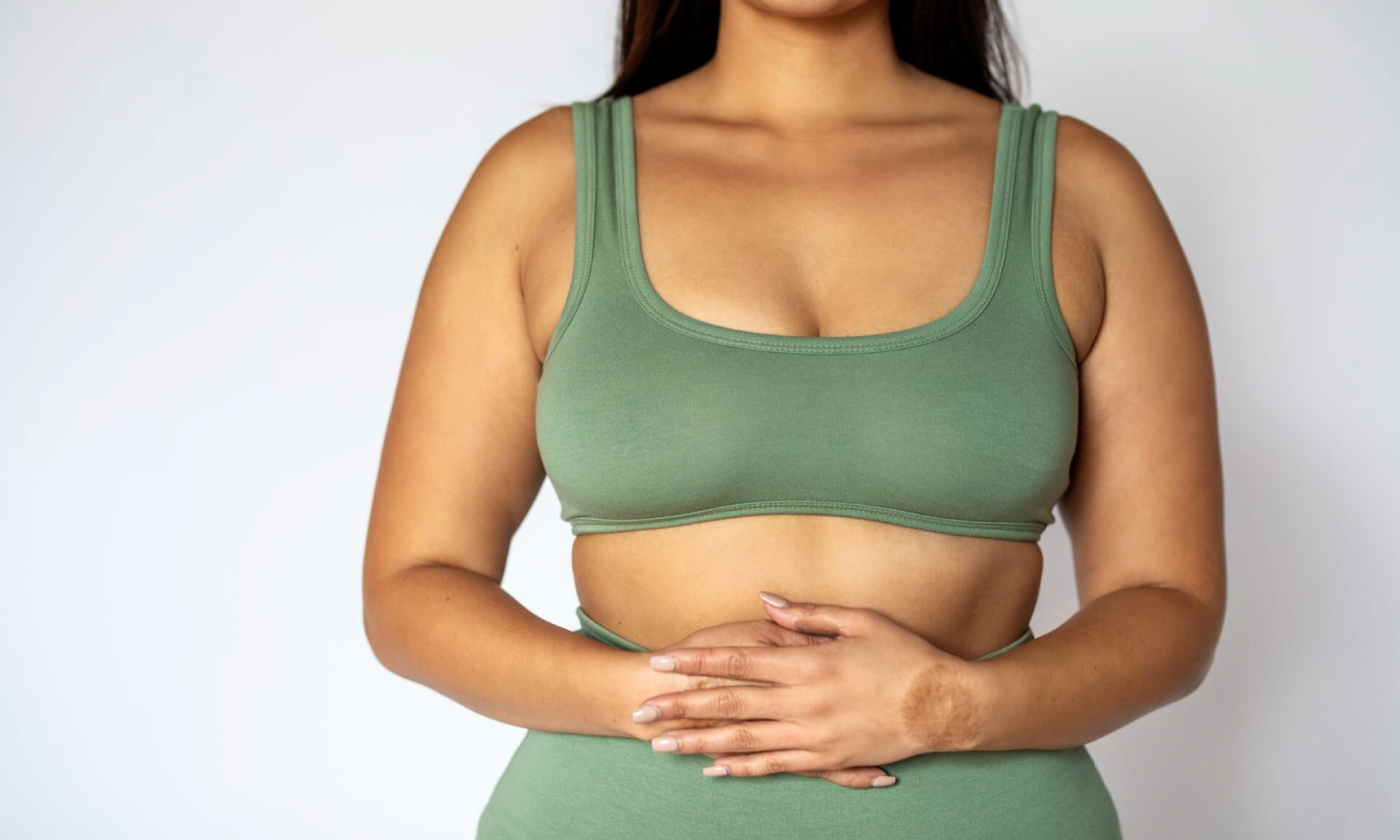woman holding her bloated stomach uncomfortably during period